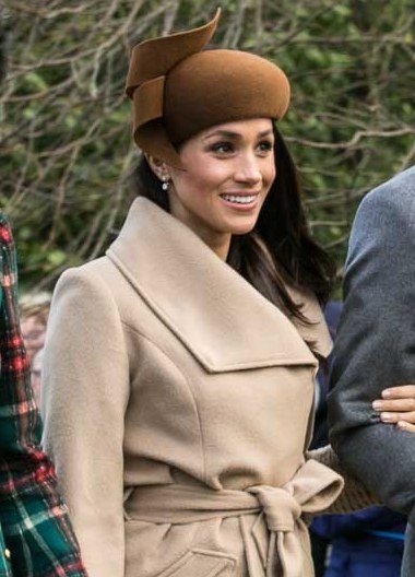Meghan Markle smiling in a beige coat and brown hat at Sandringham on Christmas Day 2017, in an article about her reported $5 million 'Suits' reunion offer